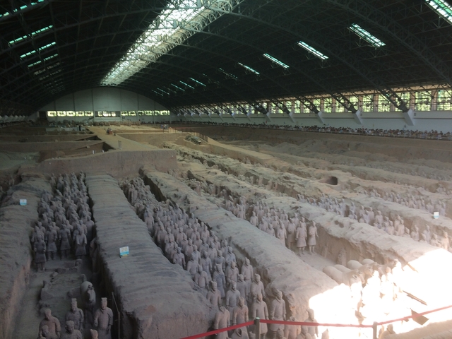 Wide view of Terracotta Army in a large excavation hall.