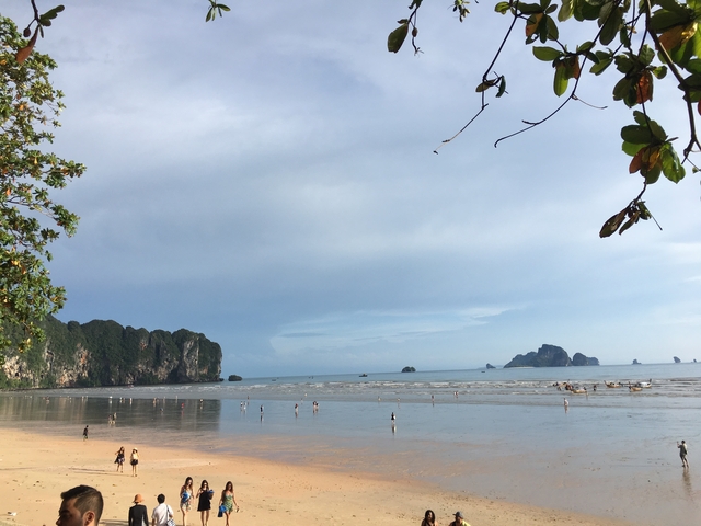 Beach with distant islands and people on the shore.