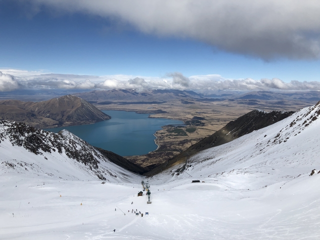 Scenic view of a mountain range and a lake surrounded by snow.