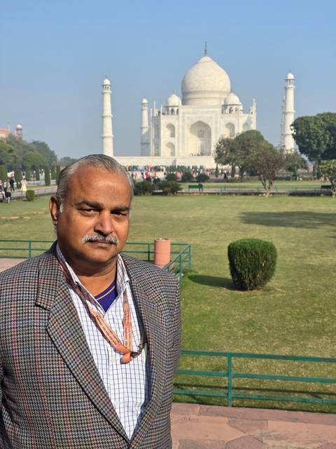 Man standing with the Taj Mahal in the background.