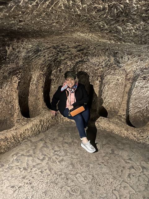 Person sitting inside a cave.