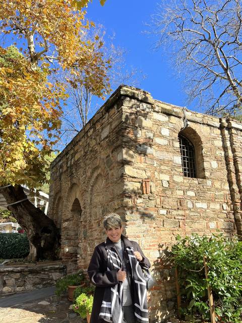 Person standing by a historical stone building.