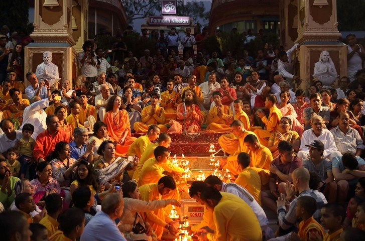 Large group of people participating in a religious ceremony with candles.