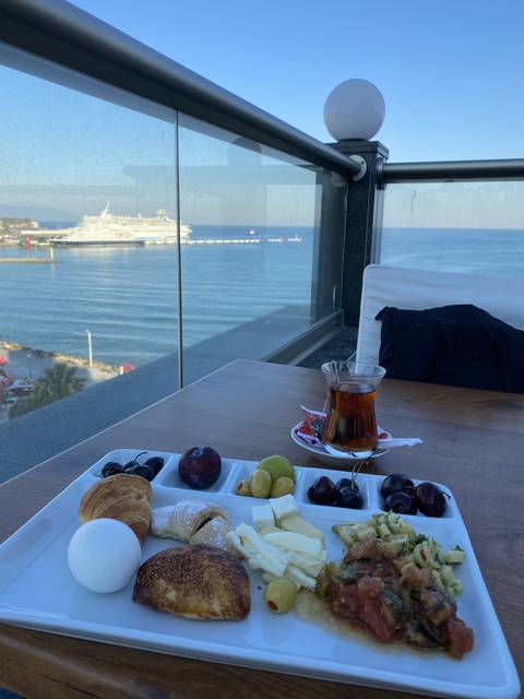       Plate of food on a balcony with a sea view
  
