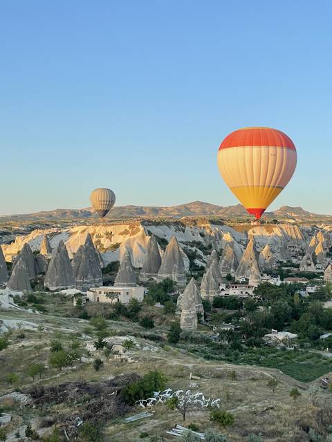       Hot air balloons flying over the unique rock formations in Cappadocia.
  
