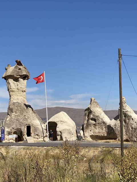       Rock formation with a Turkish flag in the foreground.
  