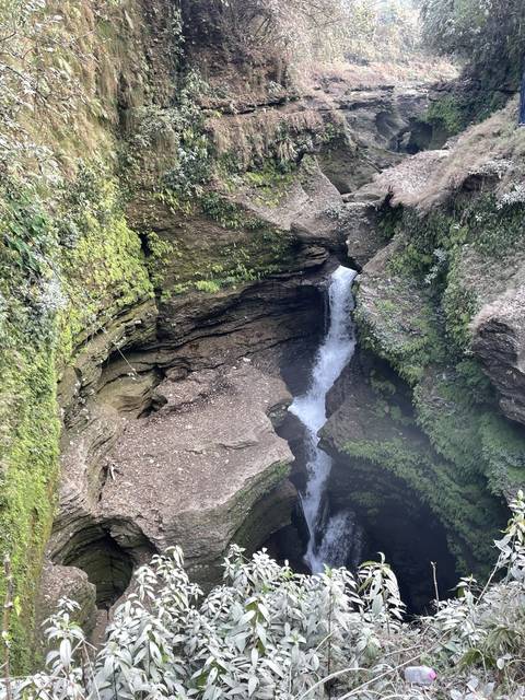       Waterfall flowing through rocky terrain.
  