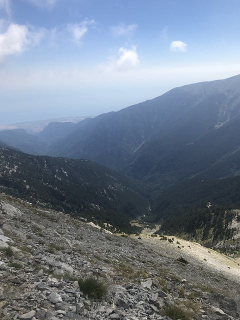 Wide view of mountain valleys under a hazy sky.