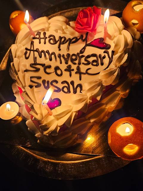       Decorated cake with anniversary message and candles.
  