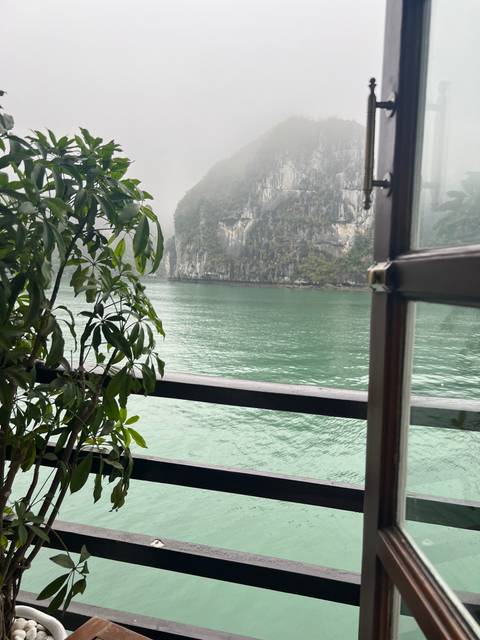       View from a boat over water with limestone cliffs.
  