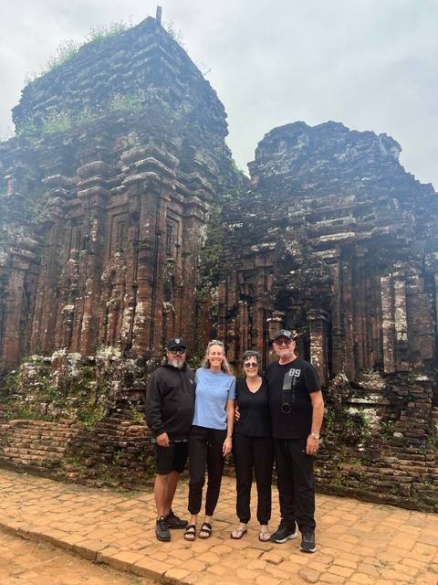       Group standing in front of a historic temple ruin.
  