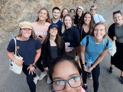       Group of smiling people taking a selfie outdoors.
  