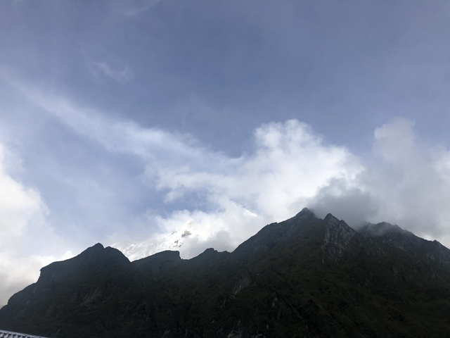 Mountain silhouette with cloudy sky.