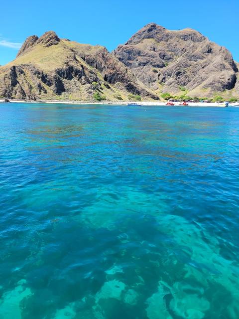       Clear blue ocean water with rocky shore
  