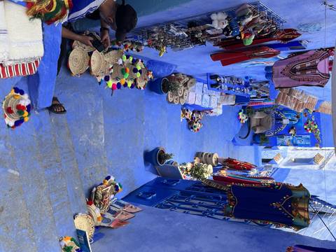       Market street with blue-themed shops and goods on display.
  