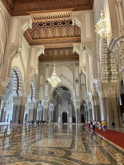       Elaborate interior of a mosque with chandeliers and ornate ceilings.
  