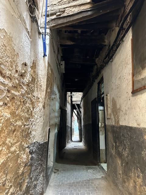       View of a narrow alleyway from a building perspective.
  