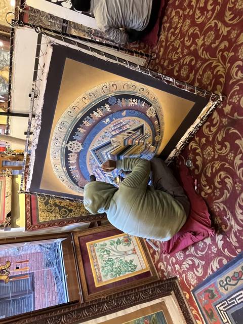       Artist working on a colorful mandala painting.
  
