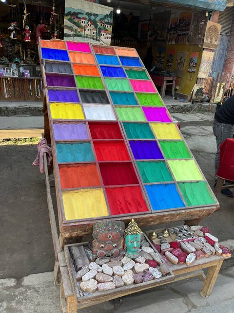       Display of multicolored powders and small painted statues.
  