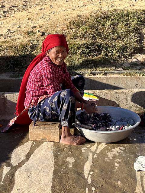 Smiling person sorting items in an outdoor setting.