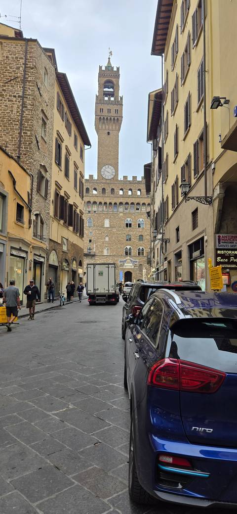       Street view with car and historic tower in Florence
  