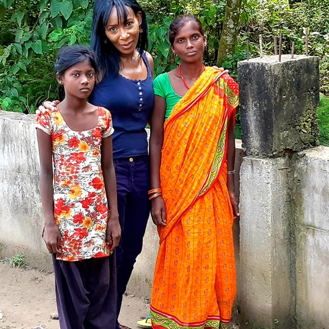       Two women and a young girl posing in traditional attire.
  