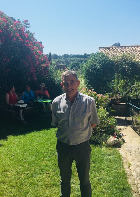 Social gathering in a garden with people enjoying drinks.