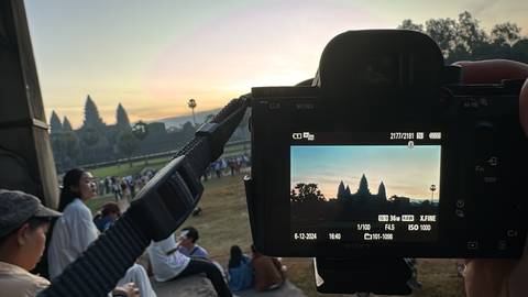 Upside-down view of a camera screen showing people and a landscape.