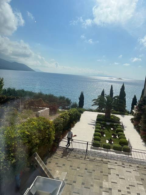 Sea view with trees and a promenade.