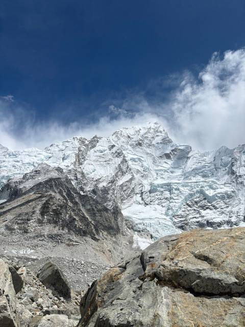 Rocks and snow surrounding a large mountain massif.