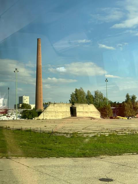 Industrial area with chimney and concrete structures.