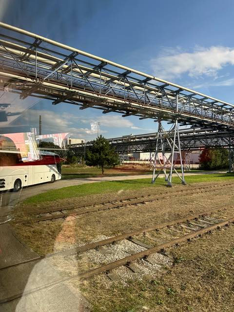 Industrial site with train tracks and steel structures.