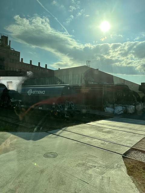       Warehouse with a truck parked near it and sun flare.
  
