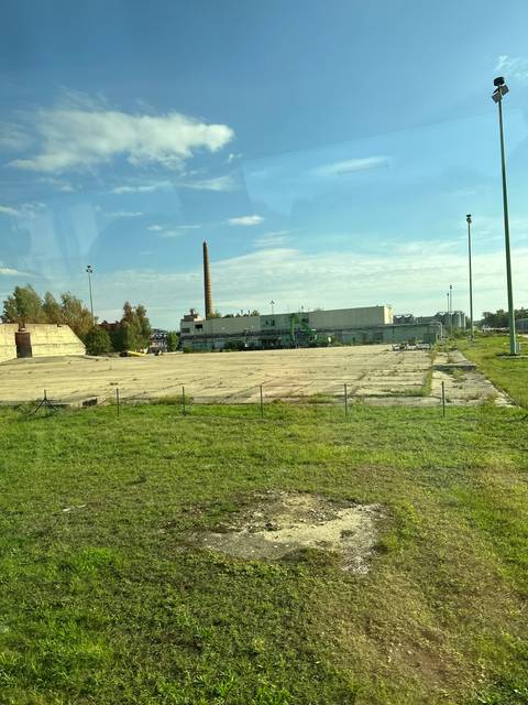 Open industrial area with chimney and buildings.