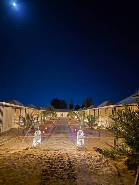      Lit pathway lined with decorative lanterns at night.
  