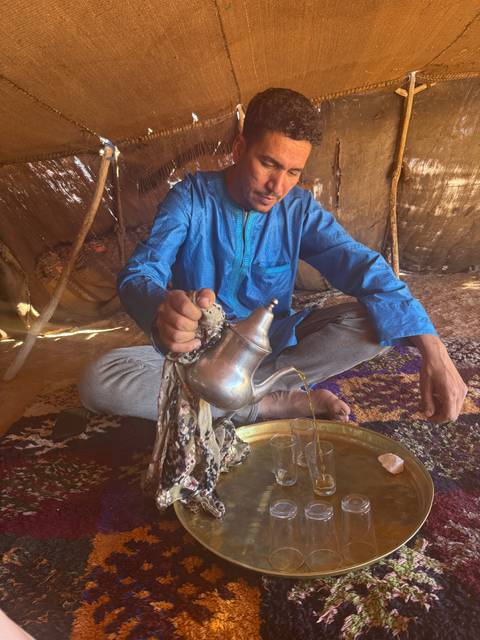 Person serving tea in a traditional setting.
