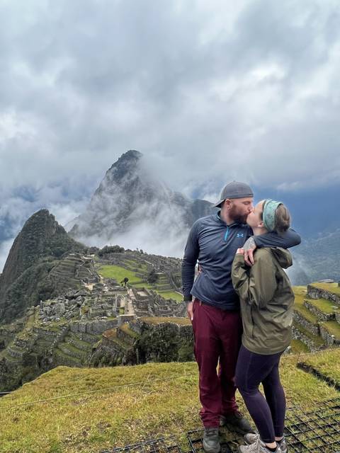 Two people embracing with a mountainous landscape in the background.
