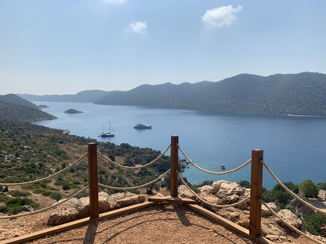       Scenic view of a bay with boats and surrounding hills.
  