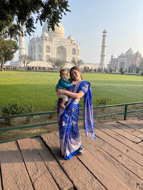       Person in traditional dress in front of the Taj Mahal.
  