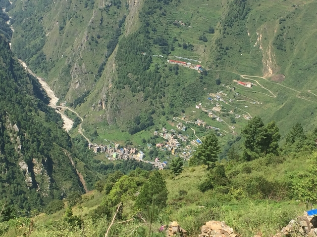 A small village nestled in a green mountainous valley.