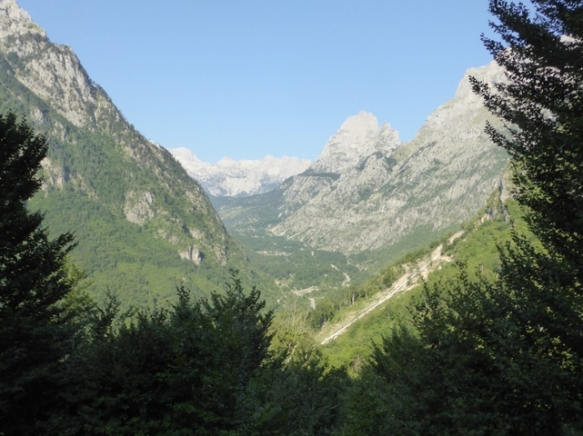 A valley with distant mountain peaks and blue skies.