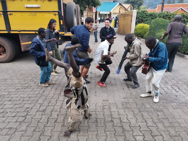 People dancing and playing music on a brick pavement.