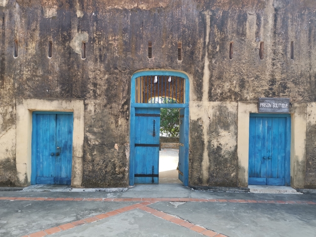       A historic building with vibrant blue doors.
  
