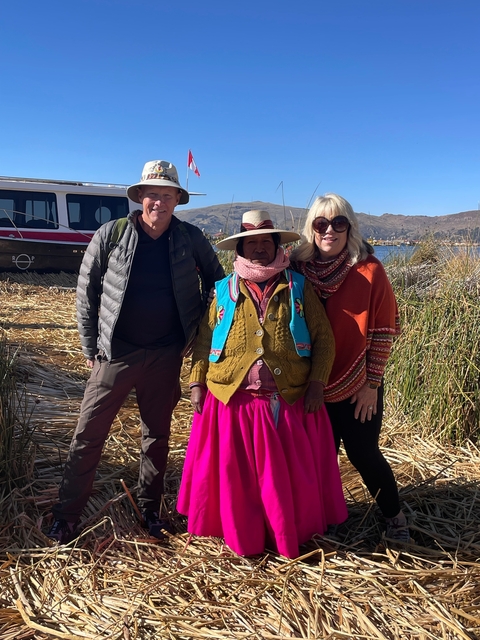       People posing with a local at Lake Titicaca.
  