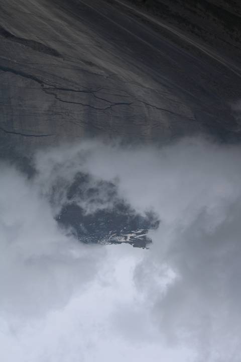 A mountain peak seen through heavy clouds.