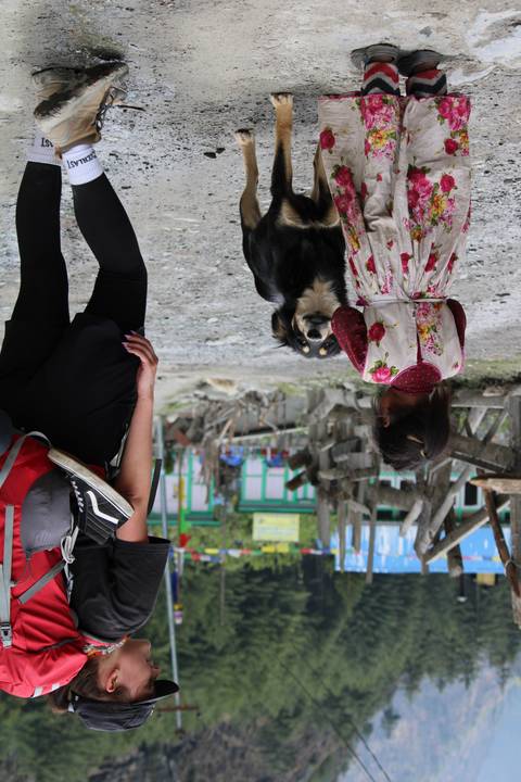 Two children and a dog on a village street.