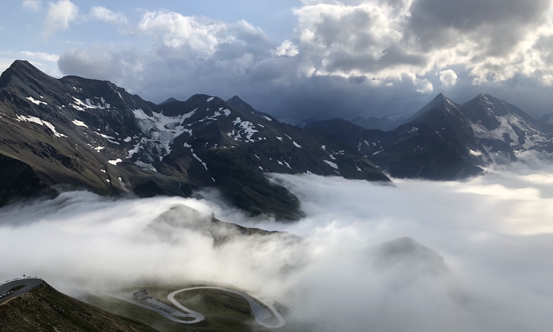 A scenic view of mountains partially covered by clouds.