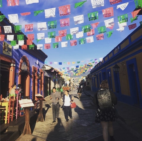 A colorful street scene with cultural decorations hanging overhead.