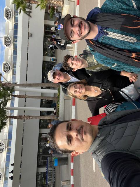 Group of people posing in front of a modern building.