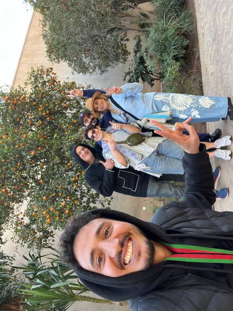       Group of people posing for a selfie in a garden.
  